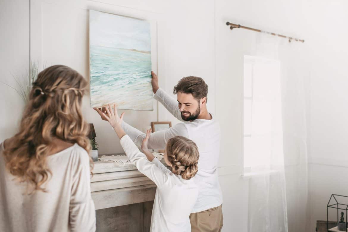 Dad hanging a frame with child